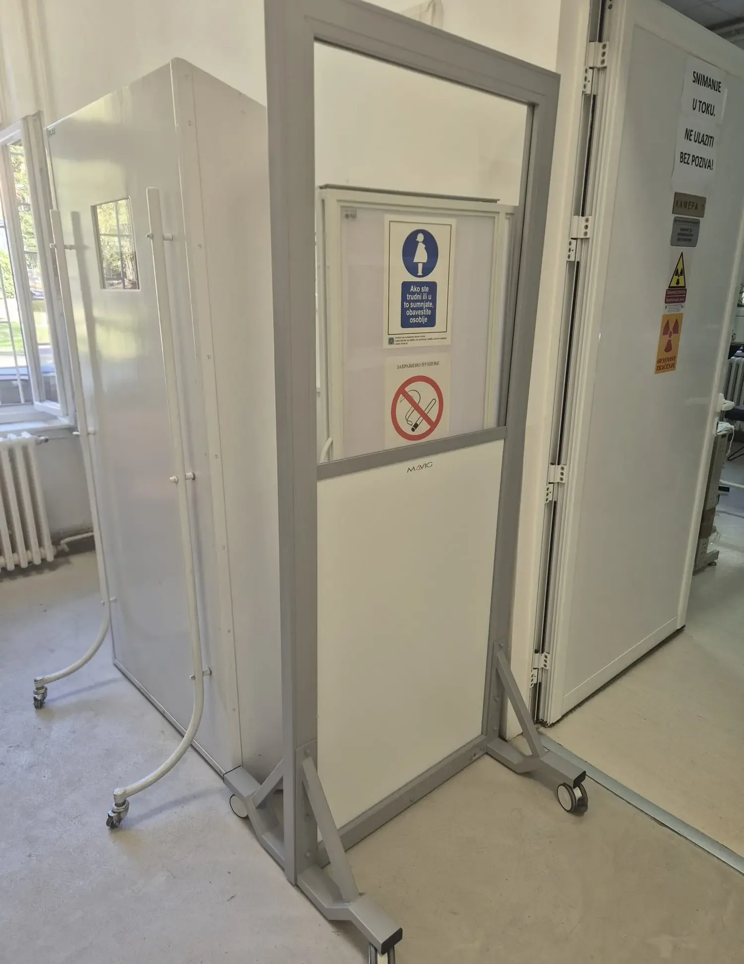 A mobile protective screen with a large lead glass pane and safety markings