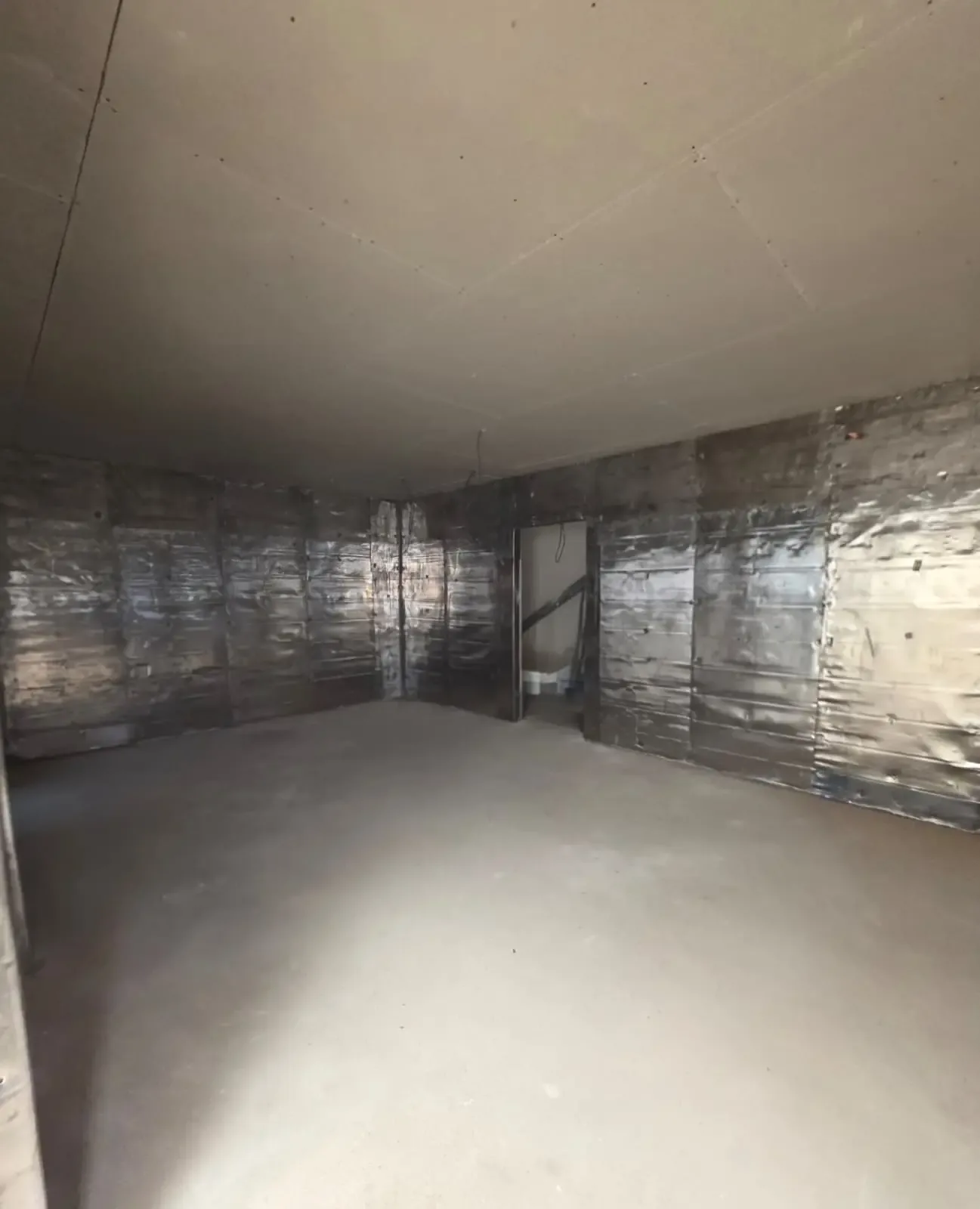 A room with walls lined in lead sheet while the shielding is being installed