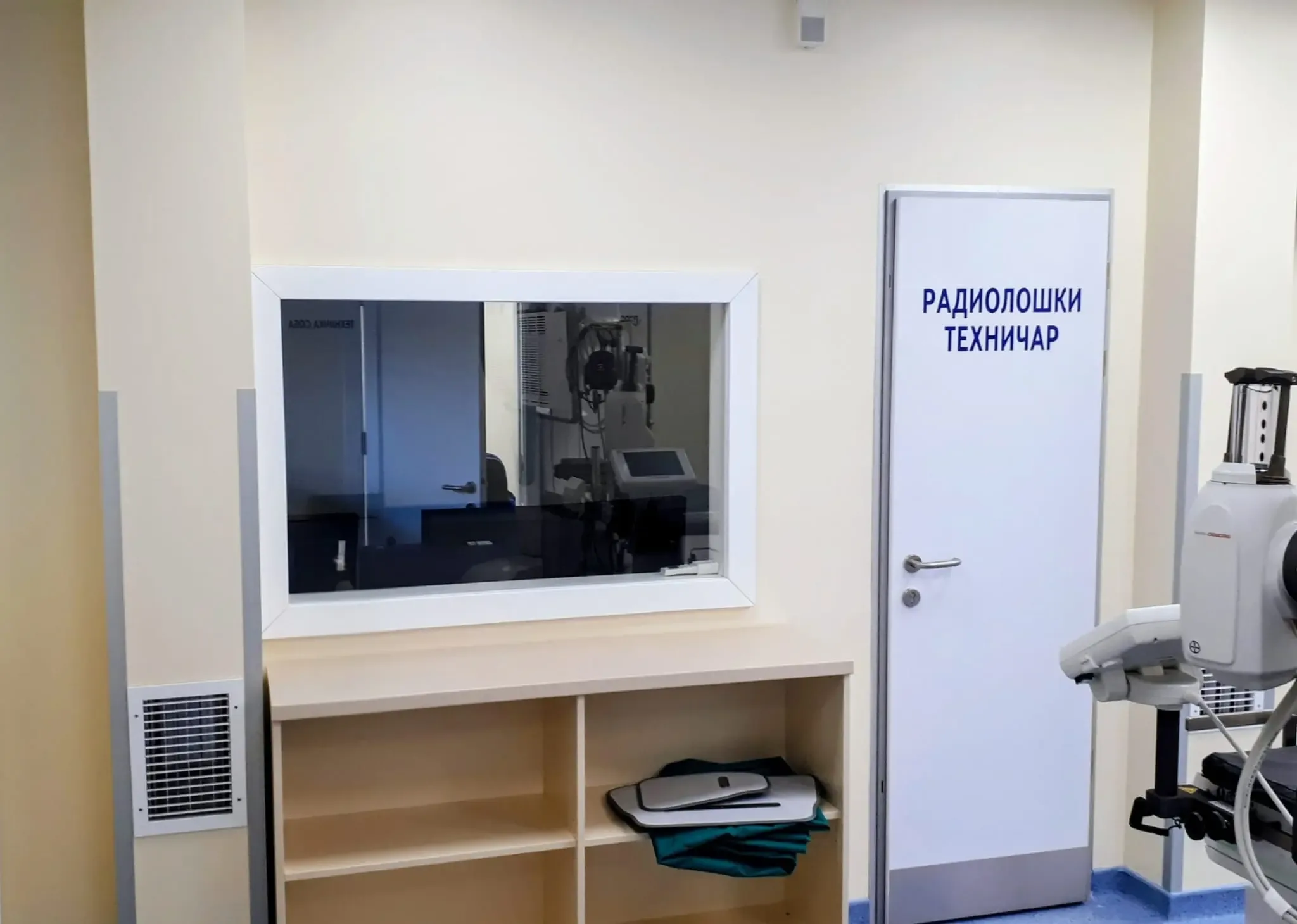 A control area with protective lead glass onto the X-ray room and the radiographer's door