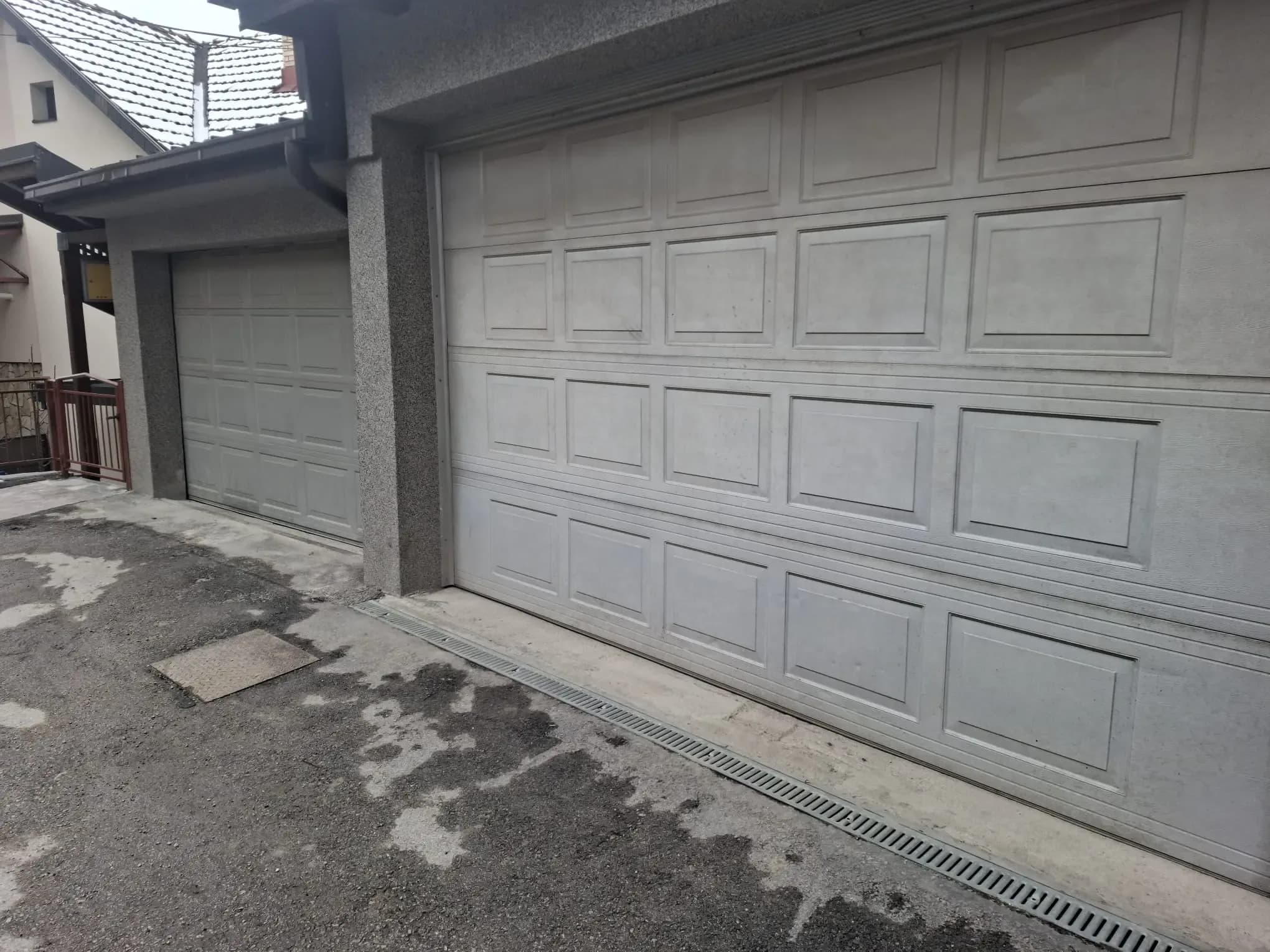 A wide sectional garage door with a panelled motif on a house under construction