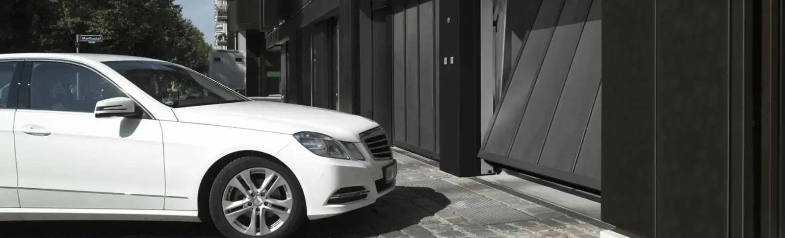 A car in front of the entrance to a communal garage with a dark door