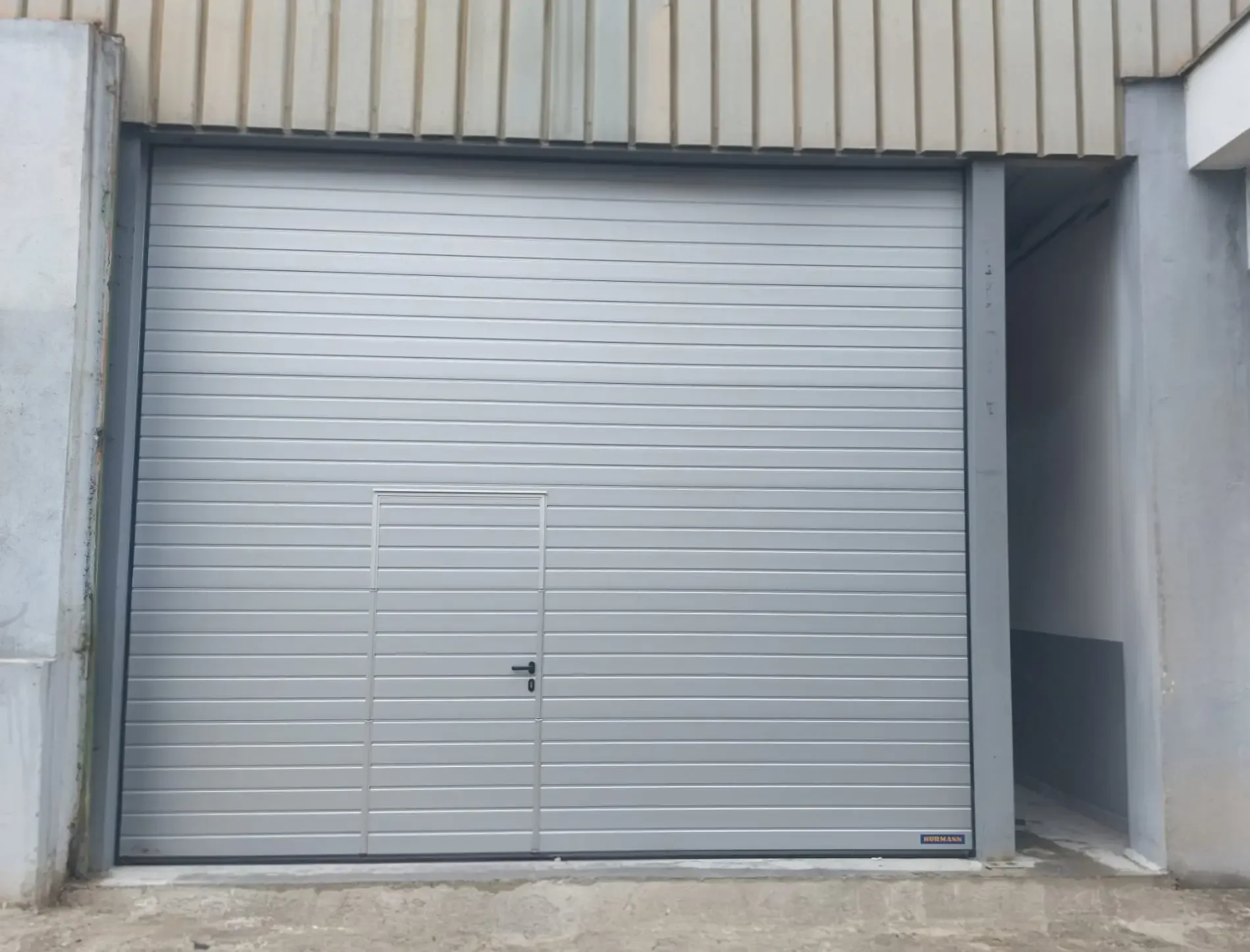 A sectional industrial door with an integrated wicket door in the opening of a hall